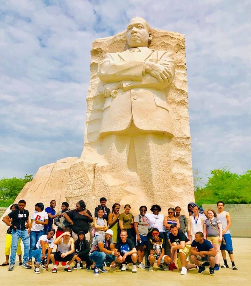 A group of students taking a picture by the statue